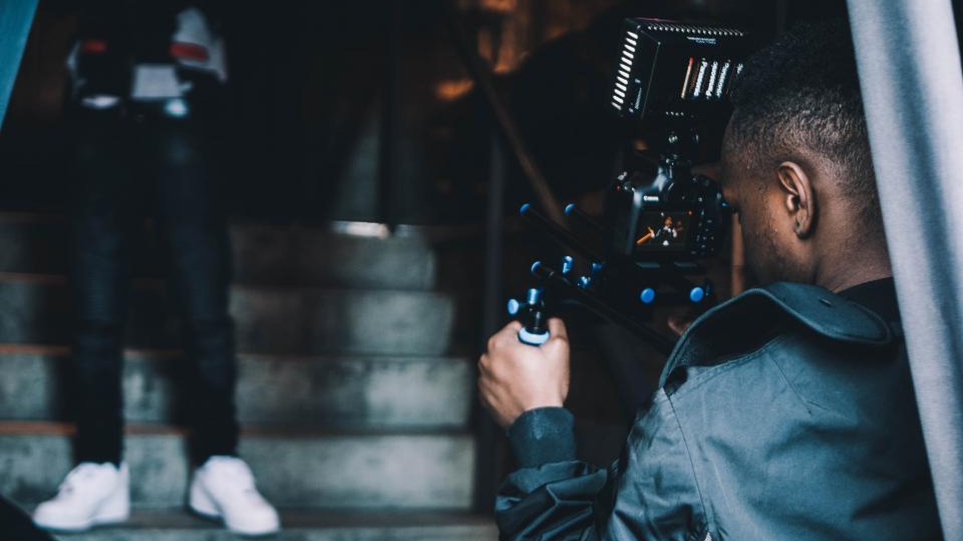 A camera operator filming on a staircase